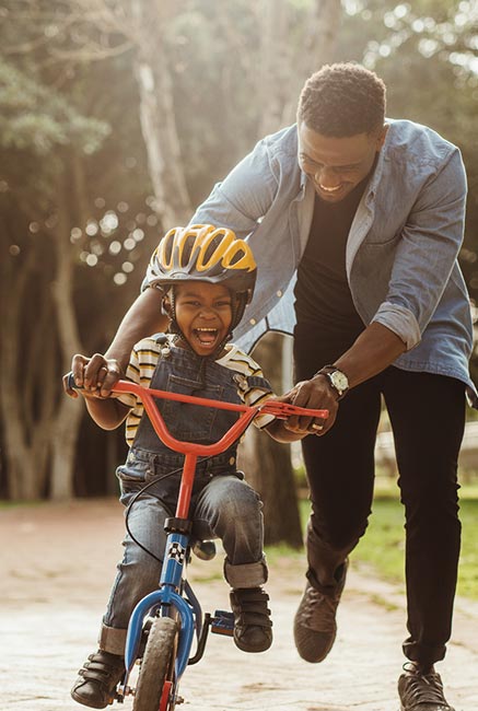 Dad teaching his son to ride a bike