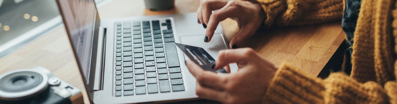 a person on their laptop with a credit or debit card