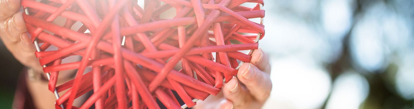 hand holding a red woven heart