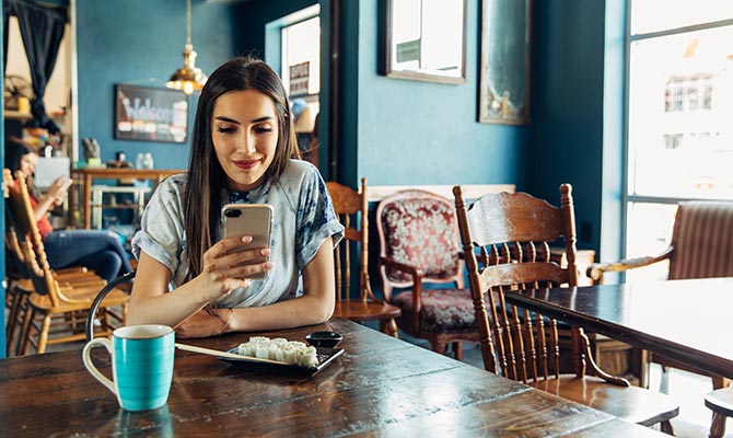 Lady using mobile banking in a restaurant